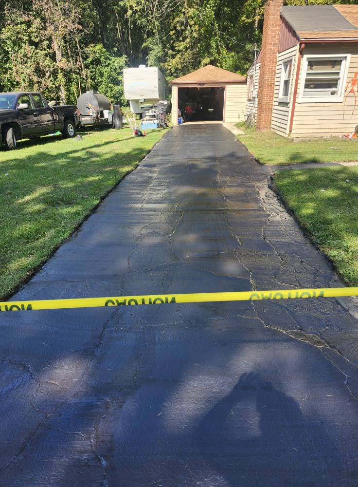 Freshly sealed driveway with clean grass edges